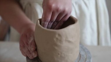 Kadın seramikçi elleri kil tabakları yontuyor
