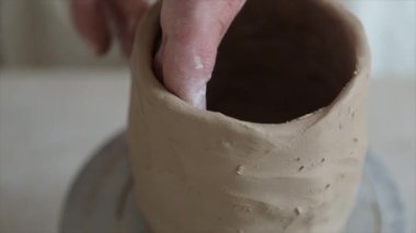 Kadın seramikçi elleri kil tabakları yontuyor