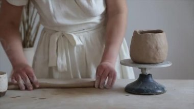 Kadın seramikçi elleri kil tabakları yontuyor