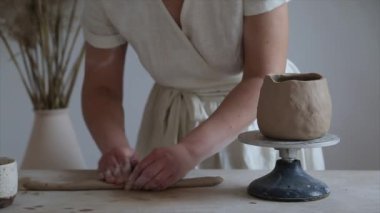 Kadın seramikçi elleri kil tabakları yontuyor