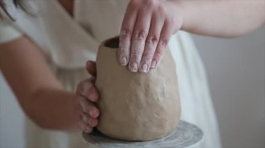 Kadın seramikçi elleri kil tabakları yontuyor