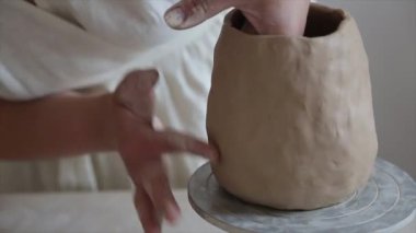 Kadın seramikçi elleri kil tabakları yontuyor