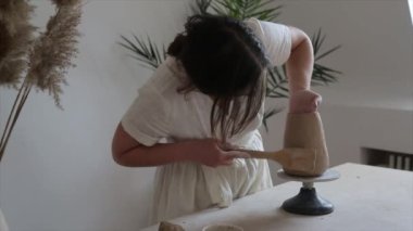 Kadın seramikçi elleri kil tabakları yontuyor