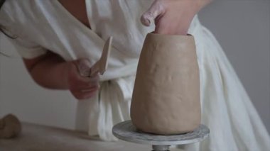 Kadın seramikçi elleri kil tabakları yontuyor