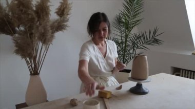 Kadın seramikçi elleri kil tabakları yontuyor