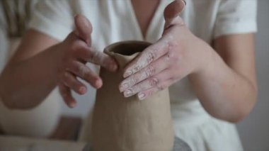 Kadın seramikçi elleri kil tabakları yontuyor