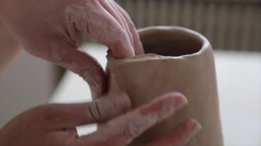 Kadın seramikçi elleri kil tabakları yontuyor