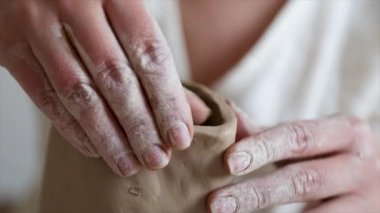 Kadın seramikçi elleri kil tabakları yontuyor