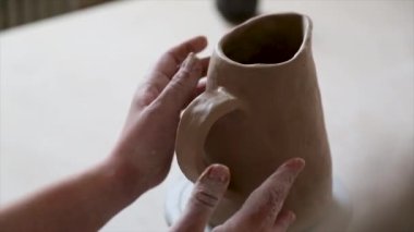 Kadın seramikçi elleri kil tabakları yontuyor