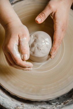 Kadın seramikçi elleri kil tabakları yontuyor