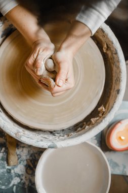 Kadın seramikçi elleri kil tabakları yontuyor
