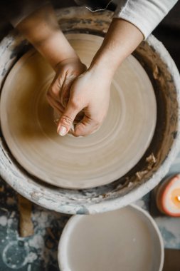 Kadın seramikçi elleri kil tabakları yontuyor