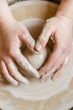 Kadın seramikçi elleri kil tabakları yontuyor