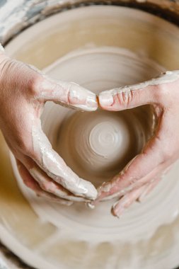 Kadın seramikçi elleri kil tabakları yontuyor