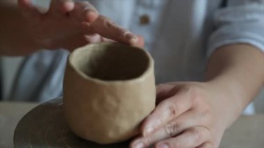 Seramist çömlekçinin çarkına çömlekçilik yapmak için çömlekçi tekerleği pedalını ayağıyla basıyor.