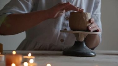 Seramist çömlekçinin çarkına çömlekçilik yapmak için çömlekçi tekerleği pedalını ayağıyla basıyor.