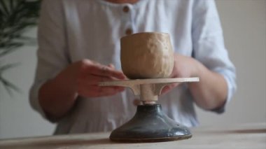 Seramist çömlekçinin çarkına çömlekçilik yapmak için çömlekçi tekerleği pedalını ayağıyla basıyor.