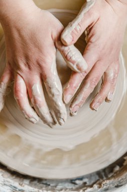 Kadın seramikçi elleri kil tabakları yontuyor