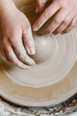 Kadın seramikçi elleri kil tabakları yontuyor