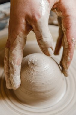 Kadın seramikçi elleri kil tabakları yontuyor