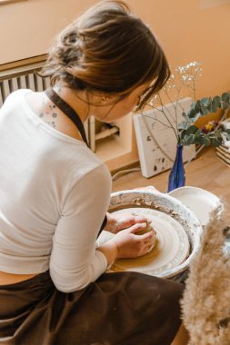 Kadın seramikçi elleri kil tabakları yontuyor