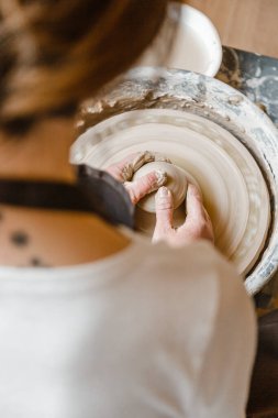 Kadın seramikçi elleri kil tabakları yontuyor