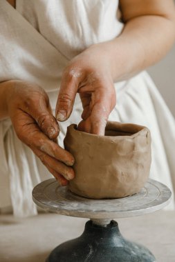 Çömlekçinin kadın elleri geleneksel şekilde kupa yapıyor. Eller kilden yemek yapar.