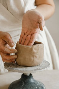 Çömlekçinin kadın elleri geleneksel şekilde kupa yapıyor. Eller kilden yemek yapar.