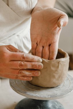Çömlekçinin kadın elleri geleneksel şekilde kupa yapıyor. Eller kilden yemek yapar.