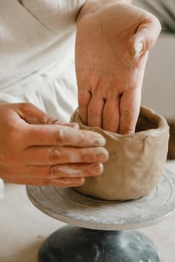 Çömlekçinin kadın elleri geleneksel şekilde kupa yapıyor. Eller kilden yemek yapar.