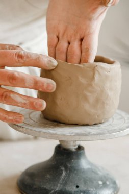 Çömlekçinin kadın elleri geleneksel şekilde kupa yapıyor. Eller kilden yemek yapar.