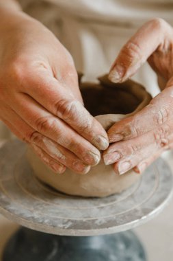 Çömlekçinin kadın elleri geleneksel şekilde kupa yapıyor. Eller kilden yemek yapar.