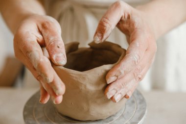 Çömlekçinin kadın elleri geleneksel şekilde kupa yapıyor. Eller kilden yemek yapar.