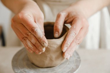 Çömlekçinin kadın elleri geleneksel şekilde kupa yapıyor. Eller kilden yemek yapar.