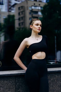 İnce, güzel sarışın manken yazın sokakta poz verir.