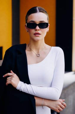 İnce, güzel sarışın manken yazın sokakta poz verir.