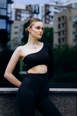 İnce, güzel sarışın manken yazın sokakta poz verir.