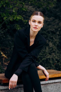 İnce, güzel sarışın manken yazın sokakta poz verir.