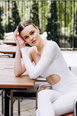 İnce, güzel sarışın manken yazın sokakta poz verir.