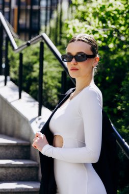 İnce, güzel sarışın manken yazın sokakta poz verir.