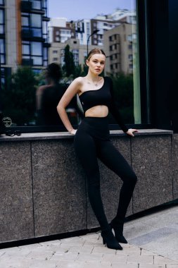 İnce, güzel sarışın manken yazın sokakta poz verir.