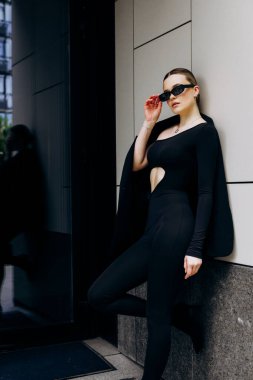 İnce, güzel sarışın manken yazın sokakta poz verir.