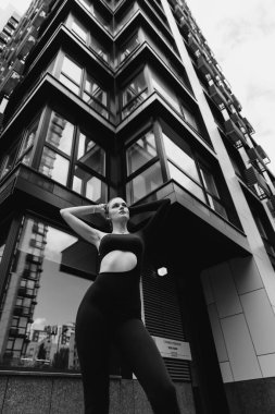 İnce, güzel sarışın manken yazın sokakta poz verir.