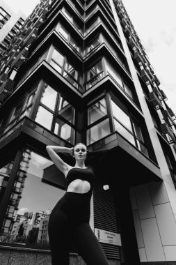 İnce, güzel sarışın manken yazın sokakta poz verir.