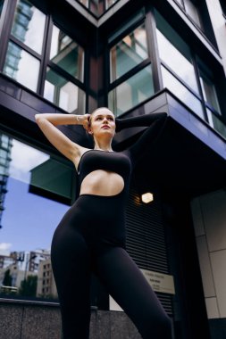 İnce, güzel sarışın manken yazın sokakta poz verir.