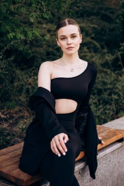 İnce, güzel sarışın manken yazın sokakta poz verir.