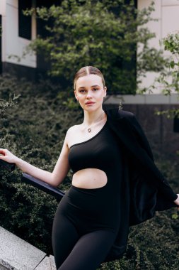 İnce, güzel sarışın manken yazın sokakta poz verir.