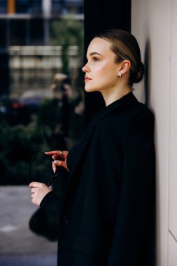 İnce, güzel sarışın manken yazın sokakta poz verir.