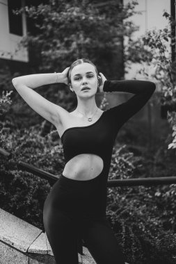 İnce, güzel sarışın manken yazın sokakta poz verir.