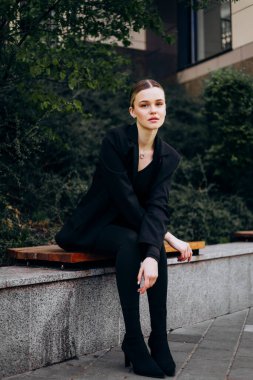 İnce, güzel sarışın manken yazın sokakta poz verir.